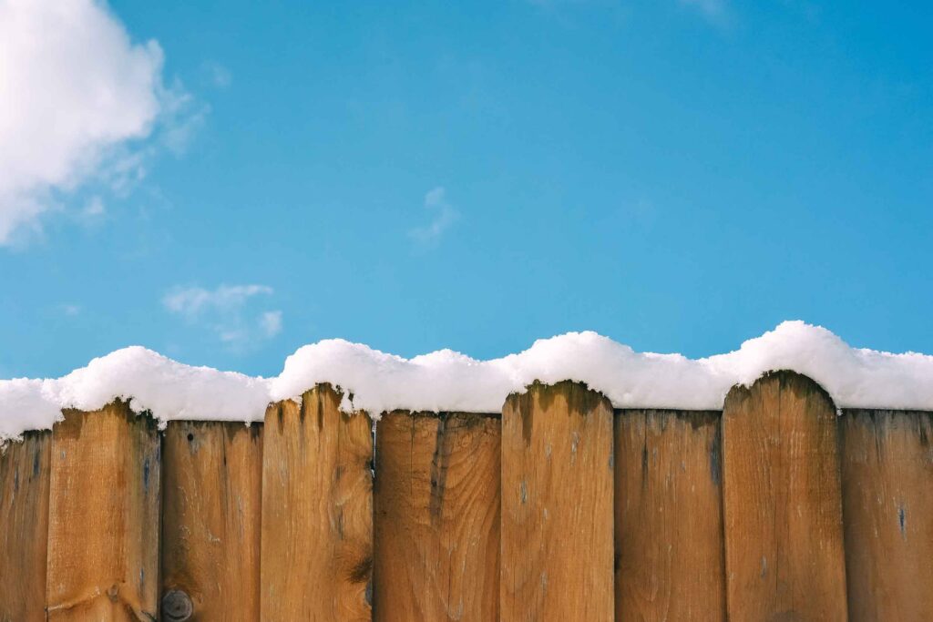 Fence in snow against the sky, winter background